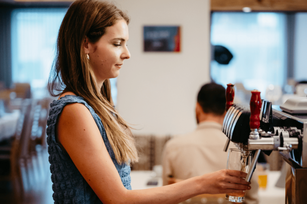 Dame zapft Getränk an der Bar