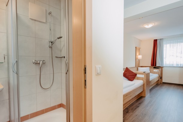 Zimmer mit Einzelbetten und Badezimmer